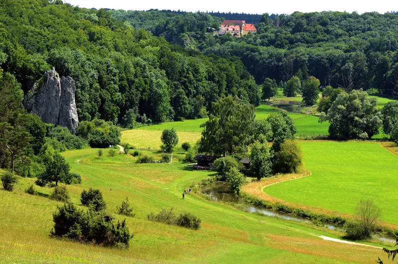 Grünes Eselsburger Tal mit der Brenz und einem hohen Kalkfelsen